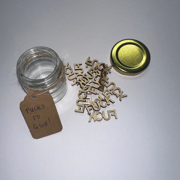 Open Glass Jar of wood words cut out saying fuck