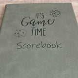 close up of gray scorepad notebook engraved with It's Game Time